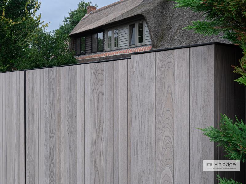 Modern wooden gate for a traditional home with thatched roof