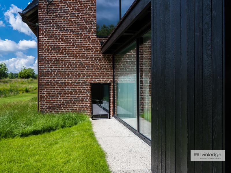 Modern timber-frame extension in charred wood with large windows