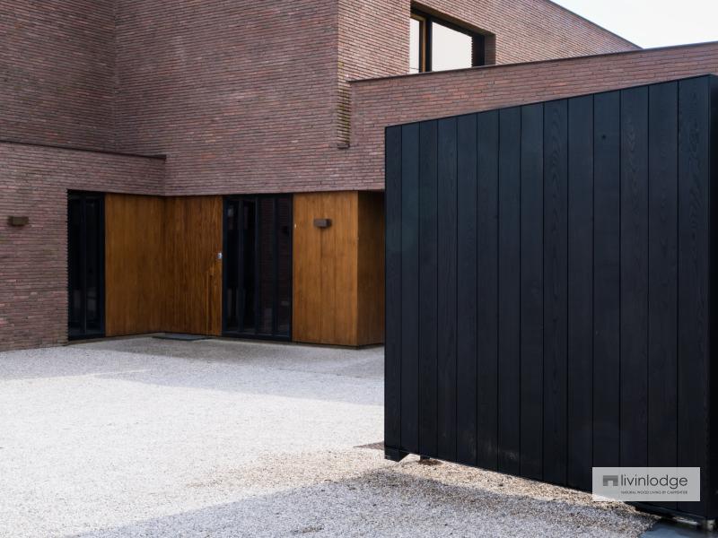 Black wooden gate, blending perfectly with a modern villa with clean lines