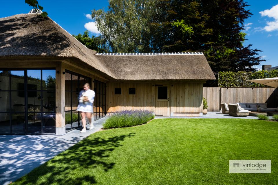 Stylish oak pool house with thatched roof and steel window frames